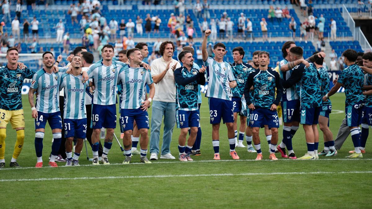 La plantilla blanquiazul celebra junto a la afición el triunfo en La Rosaleda frente al Andorra.
