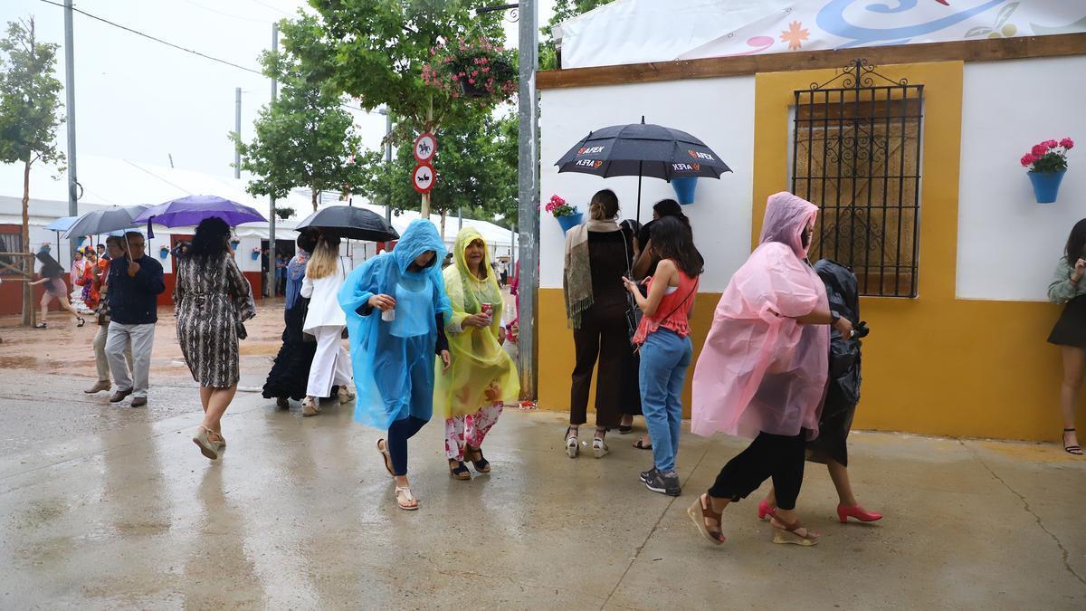 Gente refugiándose de la lluvia en la Feria de Córdoba.