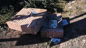 Restos de la matrículo y del parachoques del coche de la víctima, sobre el monolito de Tres Arroyos, en el lugar del crimen.