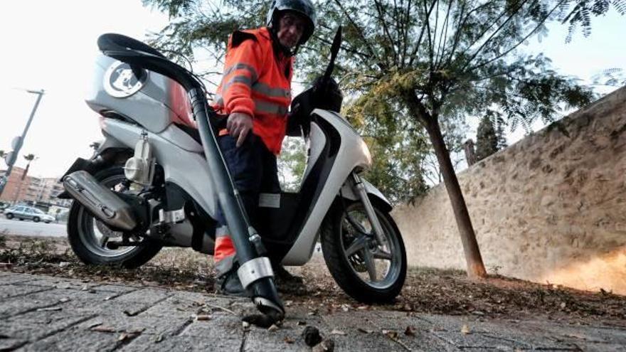 El operario mientras trabaja subido a la scooter, ayer por la tarde.