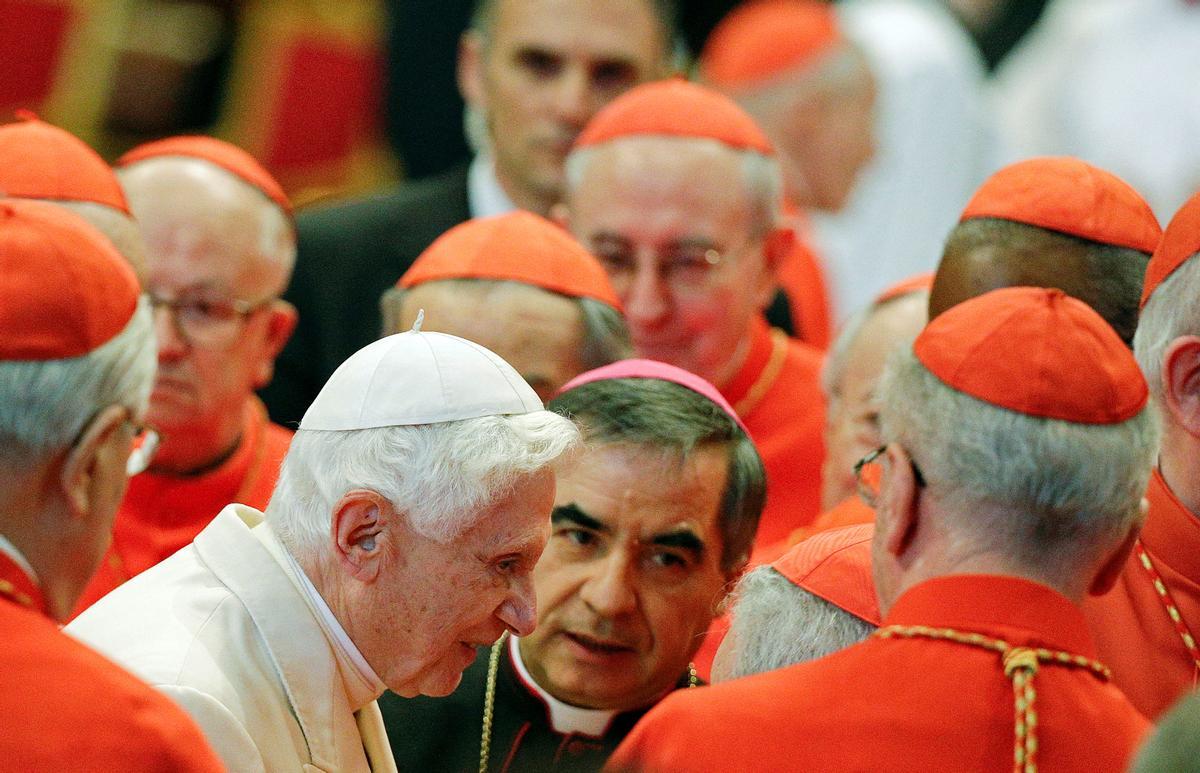 El papa emérito Benedicto XVI es recibido por algunos cardenales durante una ceremonia en la basílica de San Pedro, en El Vaticano, el 22 de febrero del 2014.