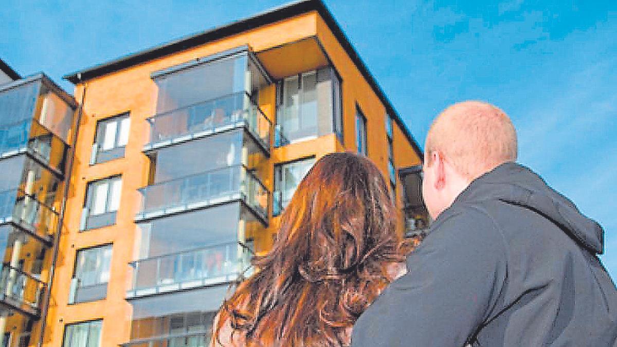 Una pareja observa una promoción de pisos.