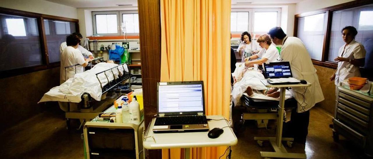 Profesionales sanitarios atienden a dos pacientes graves en los boxes de Urgencias del Hospital San Agustin.