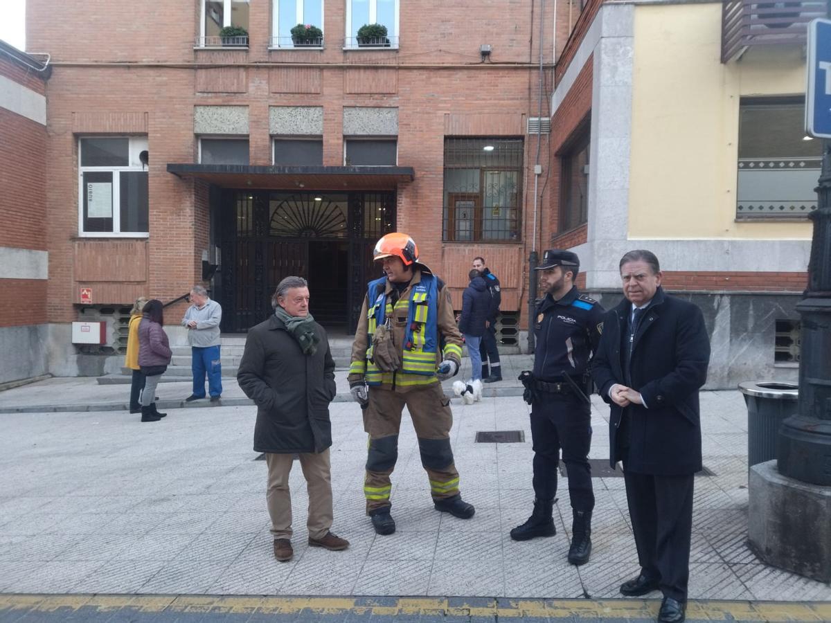 Canteli, a la derecha, y el concejal Prado, a la izquierda, con efectivos del SEIS y de la Policía Local junto al portal donde se produjo el fuego.