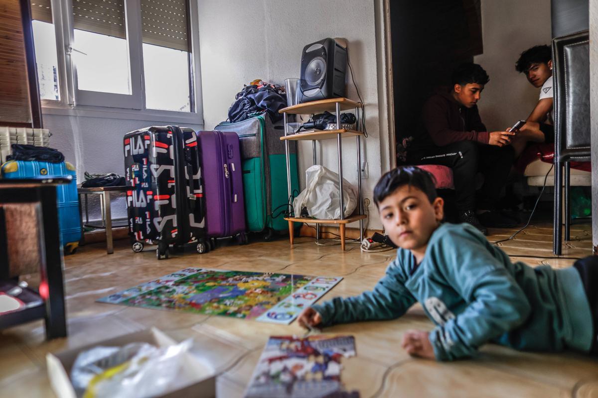 Jacabo, un niño de seis años que no ha podido ir al médico por no estar empadronado en Ripoll, juega en el suelo.