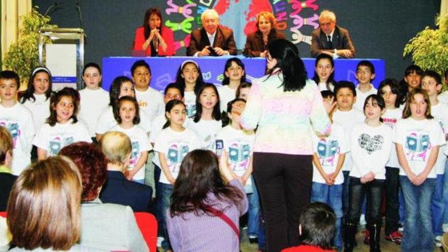 Un coro de alumnos del Colegio Los Campos, dirigido por Nuria Morgado, entona el nuevo himno del colegio, con las autoridades a sus espaldas.
