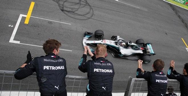 Los mecánicos de Mercedes celebran mientras su piloto británico Lewis Hamilton pasa la línea de meta para ganar el Gran Premio de F1 de Brasil en el circuito de Interlagos en Sao Paulo, Brasil.