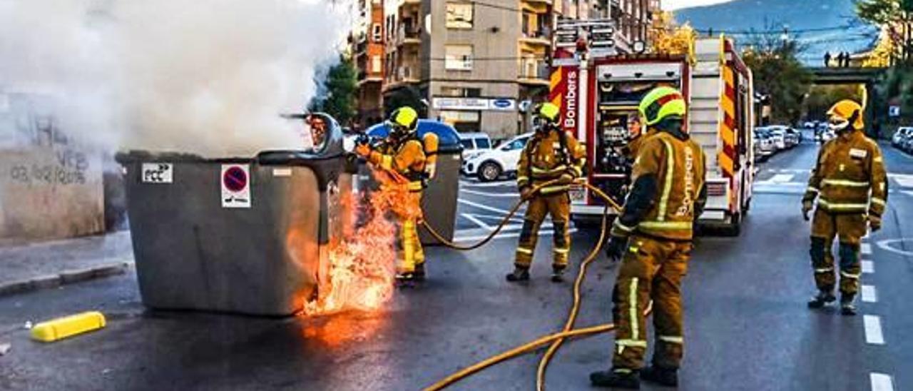 Los bomberos apagan el fuego que afectó ayer a los contenedores de Escultor Peresejo.