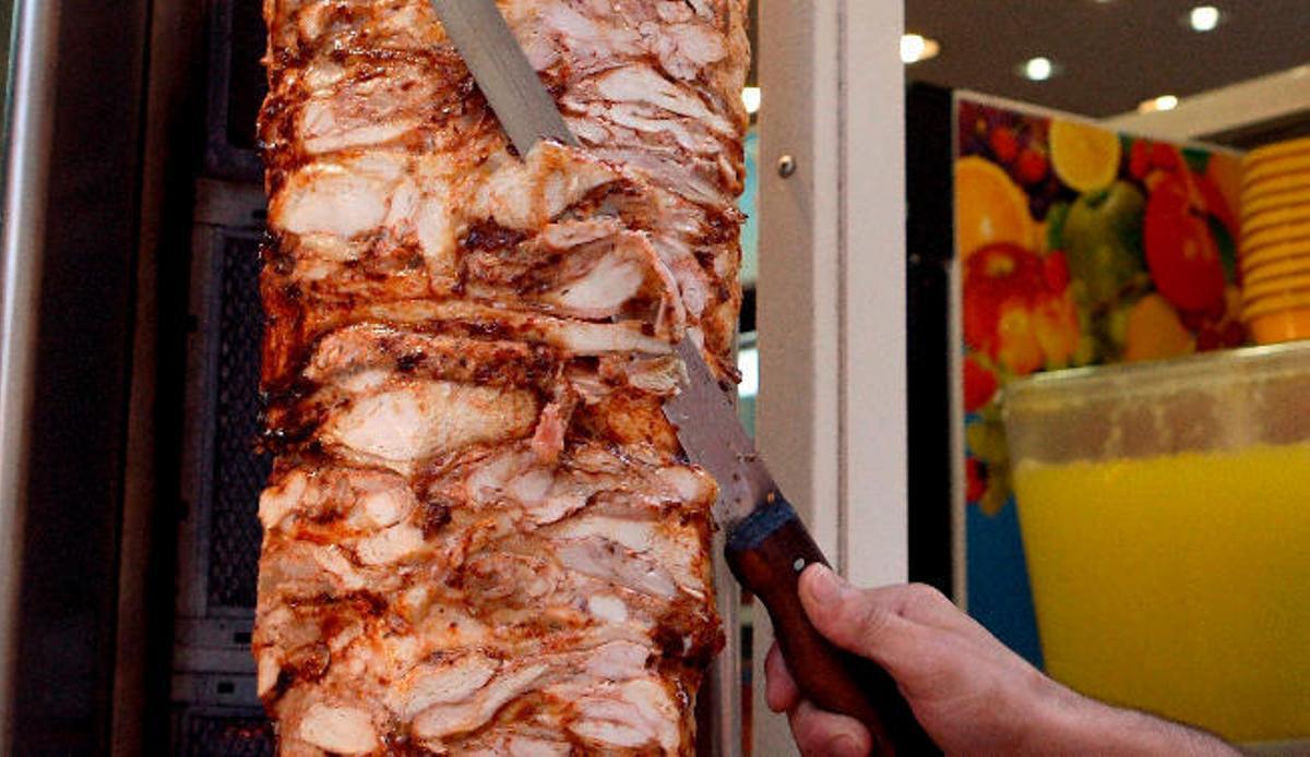 Un cocinero rebana un kebab en una imagen de archivo.