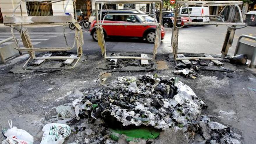 Estado en el que han quedado los cuatro contenedores situados en la confluencia de las calles de Isabel la Católica con Cirilo Amorós, tras arder.