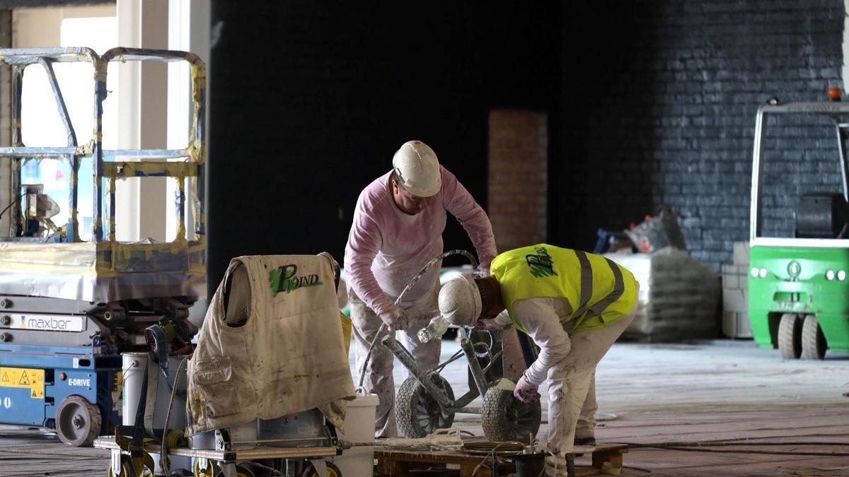 Dos trabajadores, en una nave industrial durante su jornada laboral.