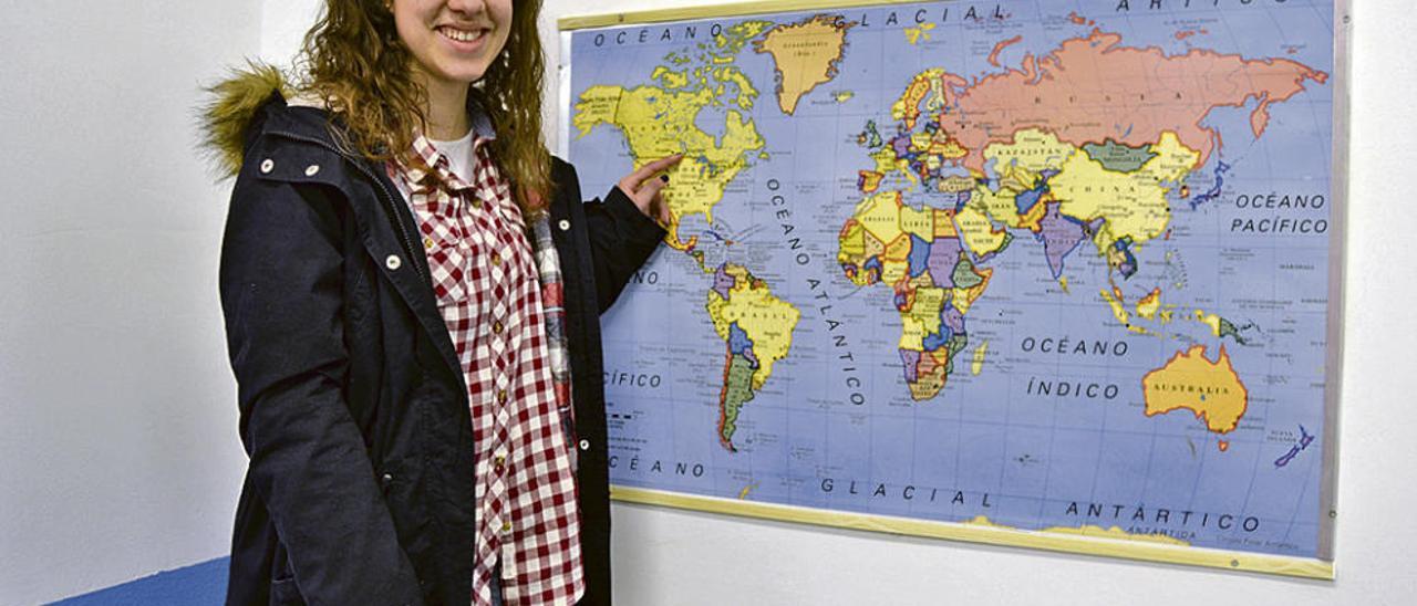 Lucía Pidal señala Canadá en un mapa de su instituto, en Luces (Colunga).