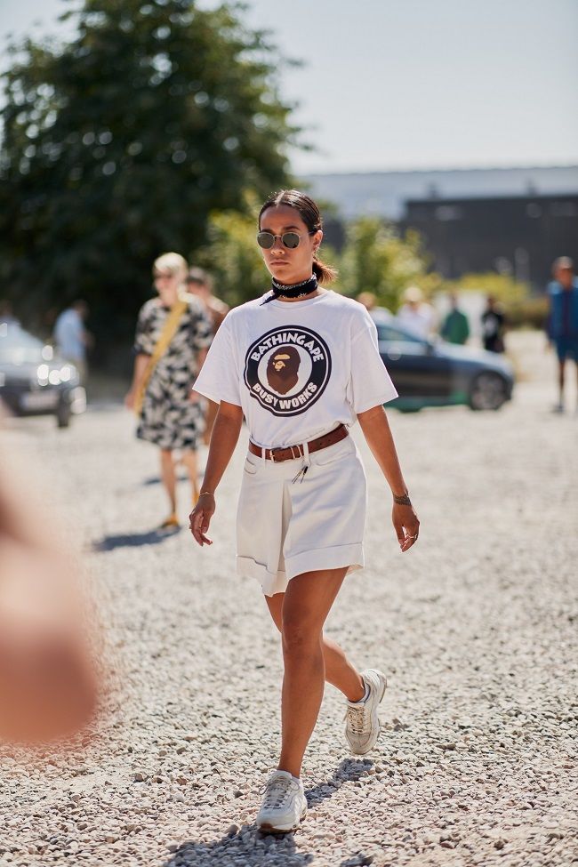 Look de zapatillas blancas combinadas con camiseta y bermudas, visto en el &#039;street style&#039; de Copenhague