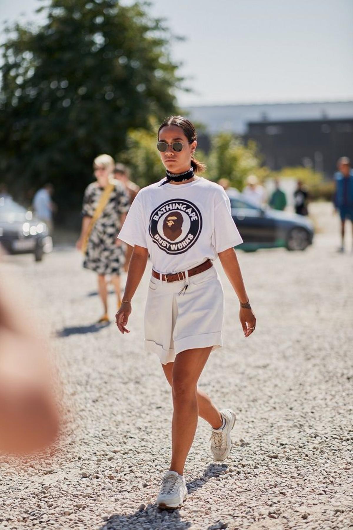 Look de zapatillas blancas combinadas con camiseta y bermudas, visto en el 'street style' de Copenhague