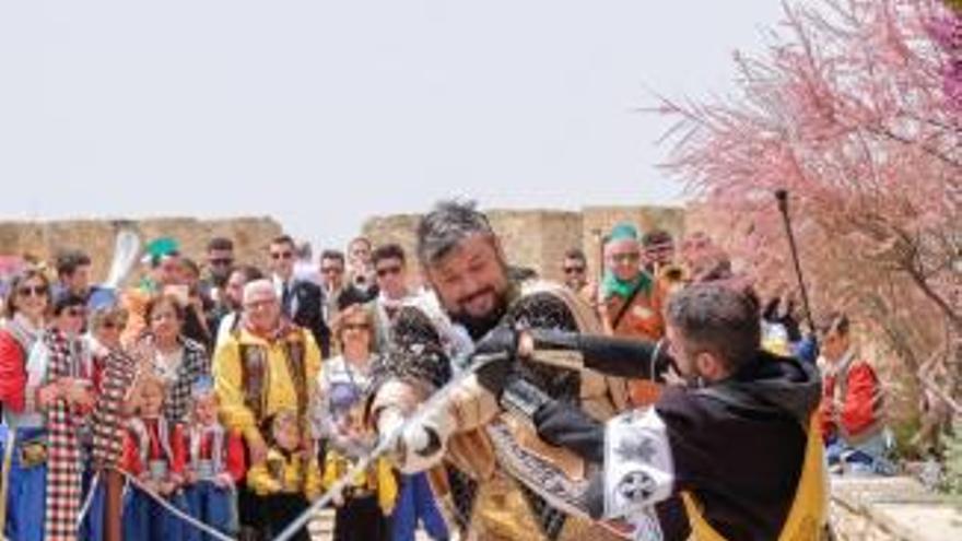 A la izquierda, el embajador moro declamando el histórico texto frente al castillo de Fiestas. A la derecha, los representantes de los dos bandos luchando.