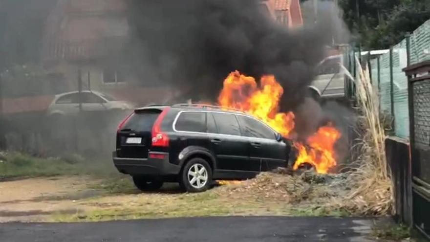 El coche, en llamas, cerca de un colegio en Priegue.