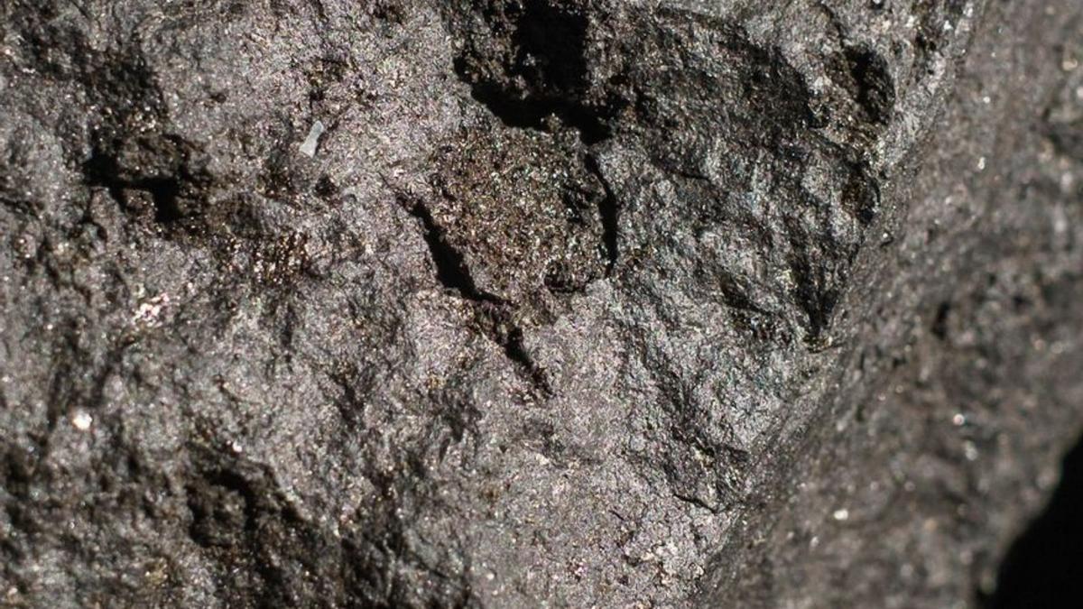 Fragmento de olivino incrustado en una piedra basáltica emitida en la erupción del volcán de La Palma. 