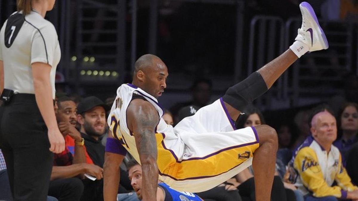 Kobe Bryant cae al suelo tras recibir una falta en el duelo entre Los Ángeles Lakers y los Mavericks de Dallas