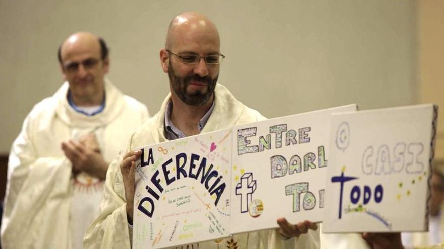 El padre Javier Gómez exhibe unos mensajes durante la misa.