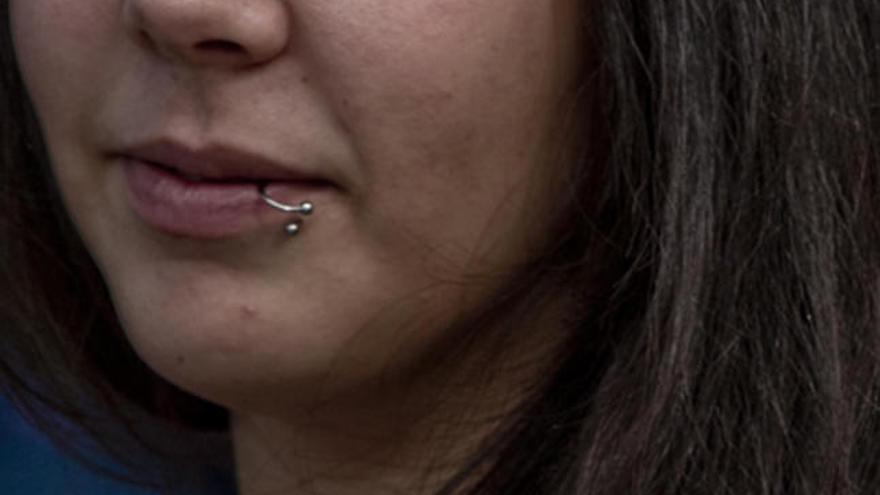 Una chica, con un &#039;piercing&#039; en sus labios.