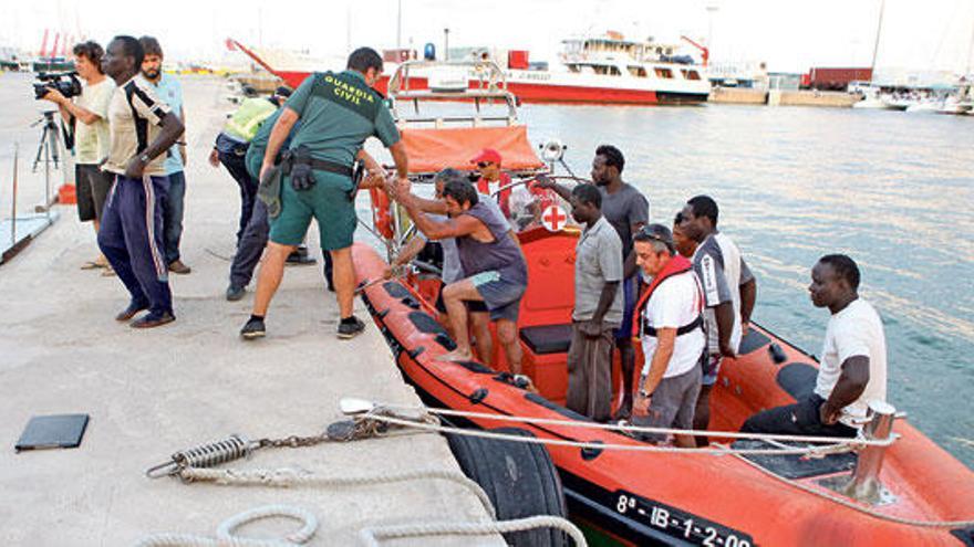 Los marineros llegan al puerto de Eivissa, tras ser rescatados del pesquero en llamas.