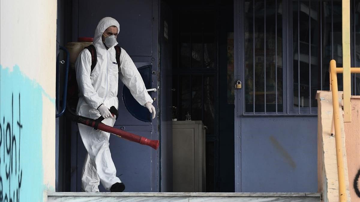 Un operario rocía desinfectante como parte de las medidas preventivas contra la propagación del coronavirus en una escuela de la localidad griega de  Salónica.
