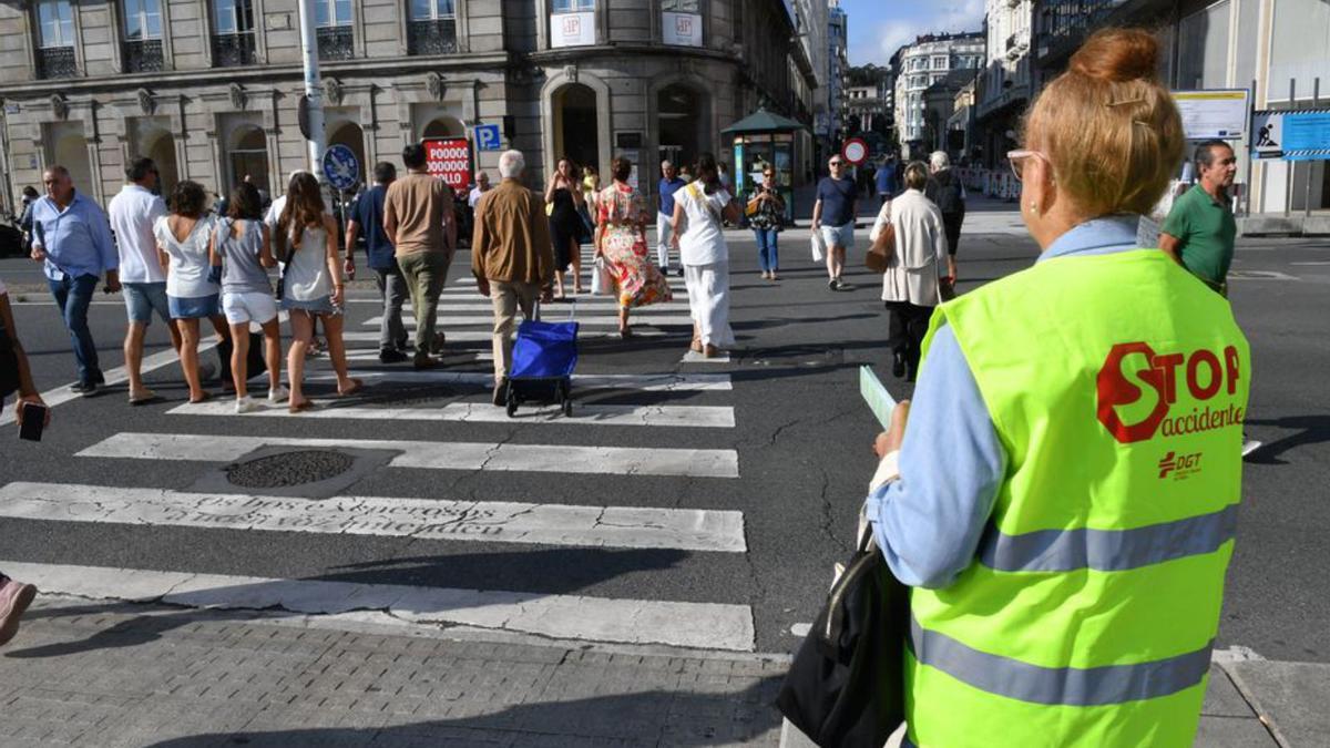 Una voluntaria de Stop Accidentes reparte información sobre movilidad a los peatones en la plaza de Mina.  | // VÍCTOR ECHAVE