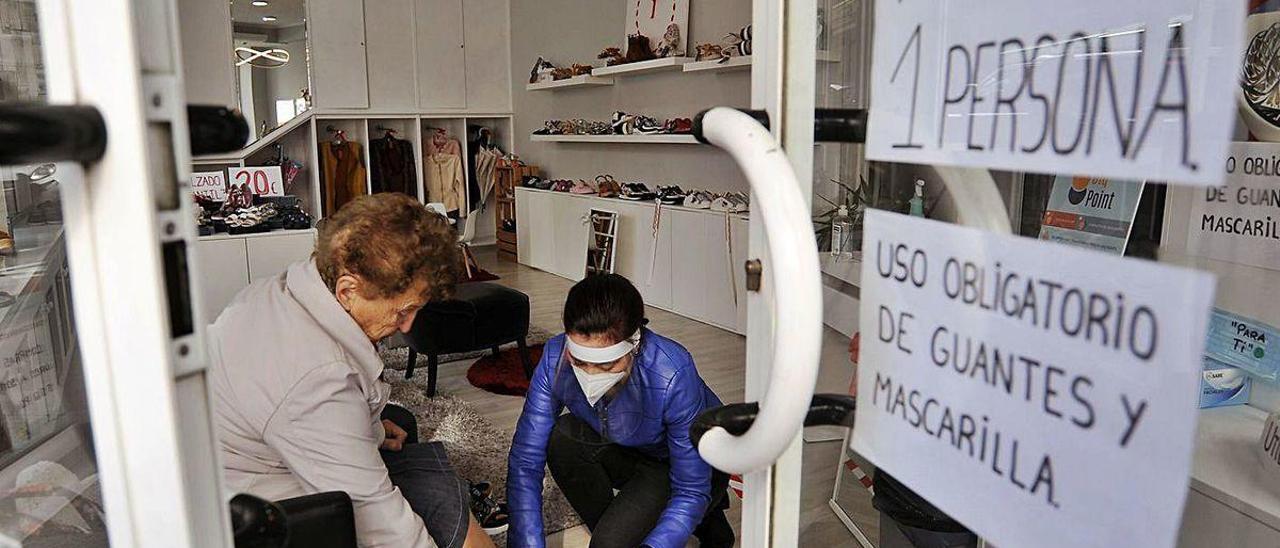 Una vecina se prueba calzado en una tienda de las comarcas.