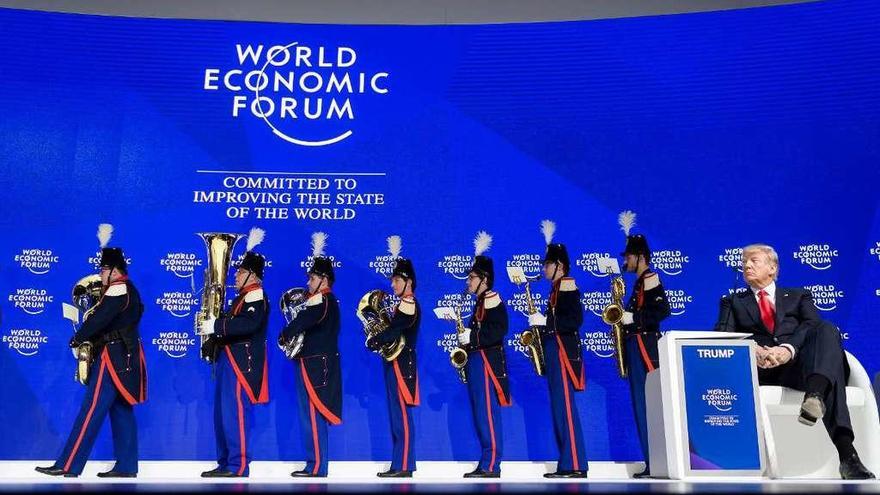 Trump aguarda su turno para intervenir en el foro de Davos, acompañado de la banda de Friburgo. // AFP