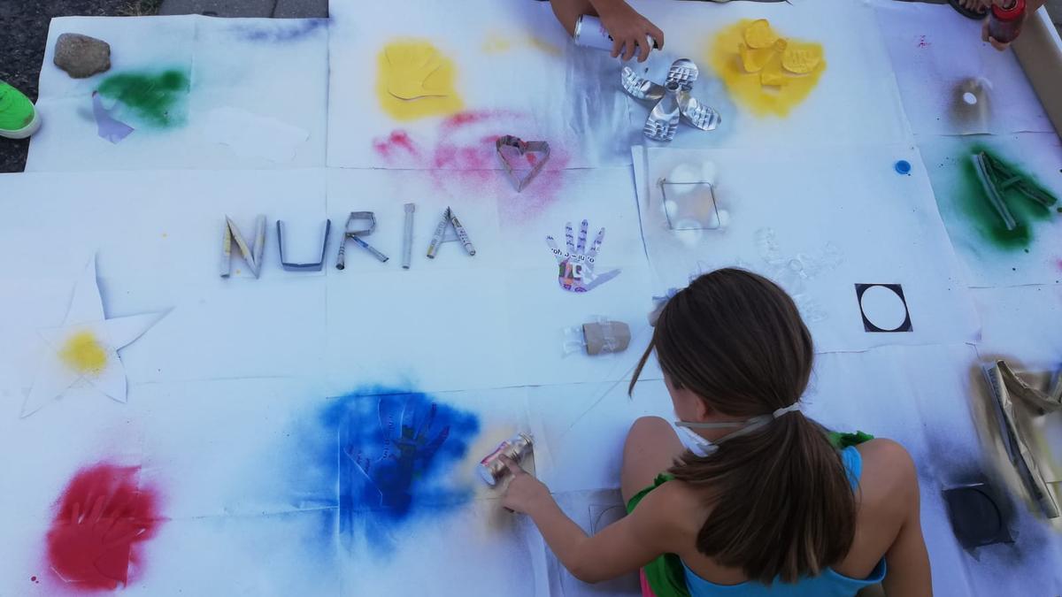 Una niña pinta en un mural, durante una actividad celebrada en Navalmoral.