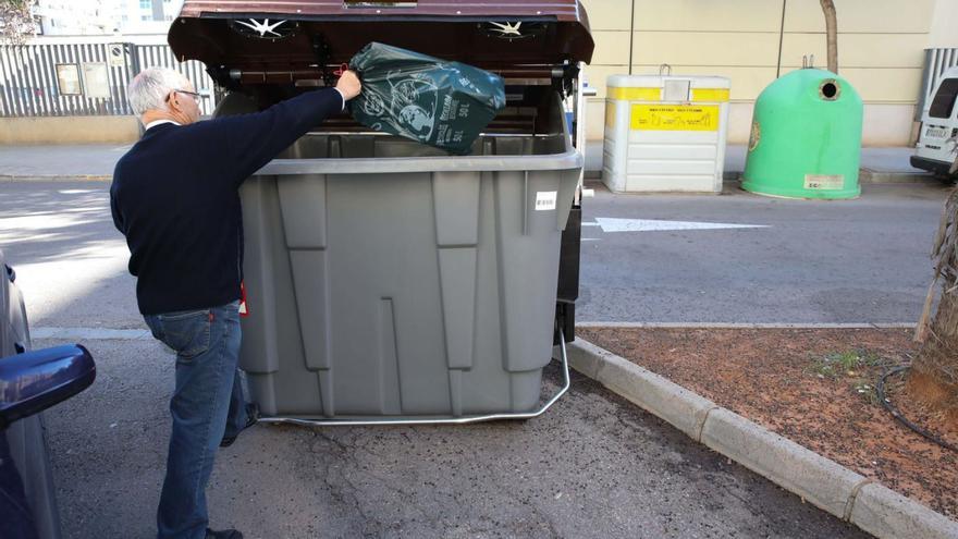 Un usuario deposita una bolsa en un contenedor de restos orgánicos.