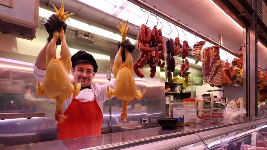 Jose Mogo muestra dos pollos en su puesto del mercado de Pontevedra.