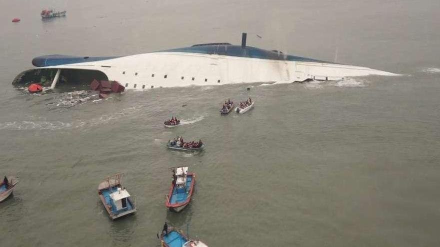 Los equipos de rescate junto al barco hundido. En el recuadro, tres jóvenes que sobrevivieron.  // Reuters