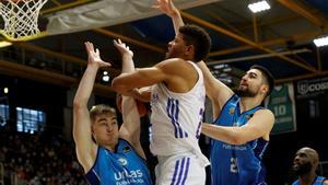 El pívot caboverdiano del Real Madrid, Walter Tavares (c) trata de encestar ante el base esloveno Ziga Samar (i) y el pívot serbio Dusan Ristic (d). 