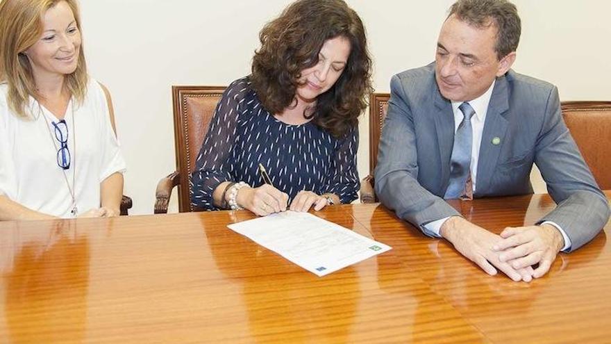 Una empleada firma su contrato ante el alcalde, José Ortiz.
