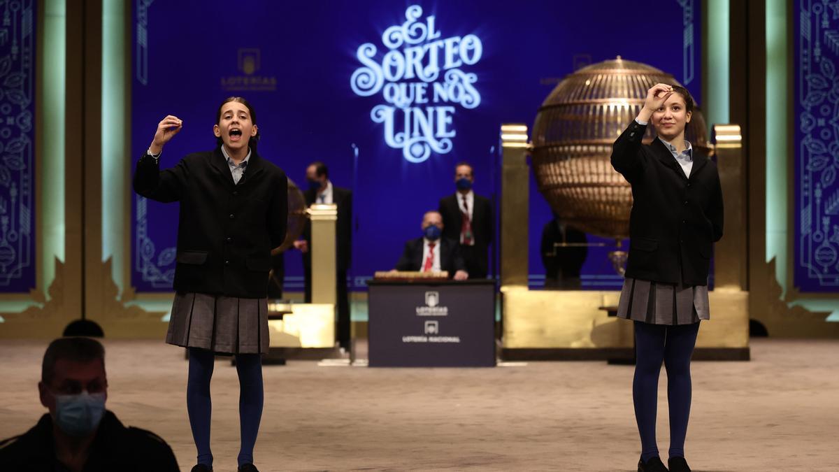 Dos de las niñas de la residencia de San Ildefonso, posan minutos después de cantar un premio durante la celebración del Sorteo Extraordinario de la Lotería de Navidad 2021.