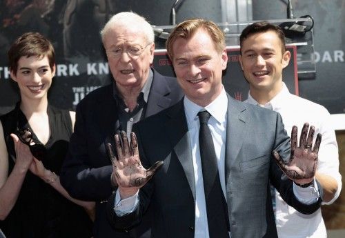 Director Nolan shows off his hands after leaving his handprints in cement in the forecourt of the Grauman's Chinese Theatre in Hollywood
