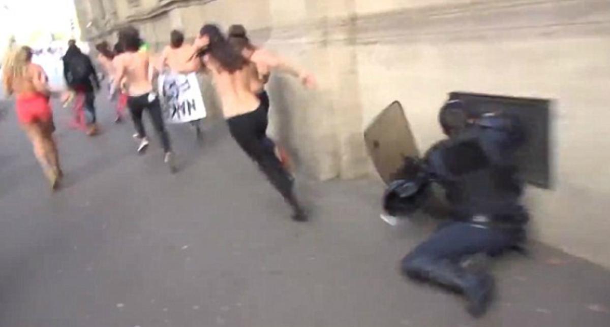 Un policia xoca contra la paret a l’intentar interceptar una activista de Femen, a París, aquest dilluns.