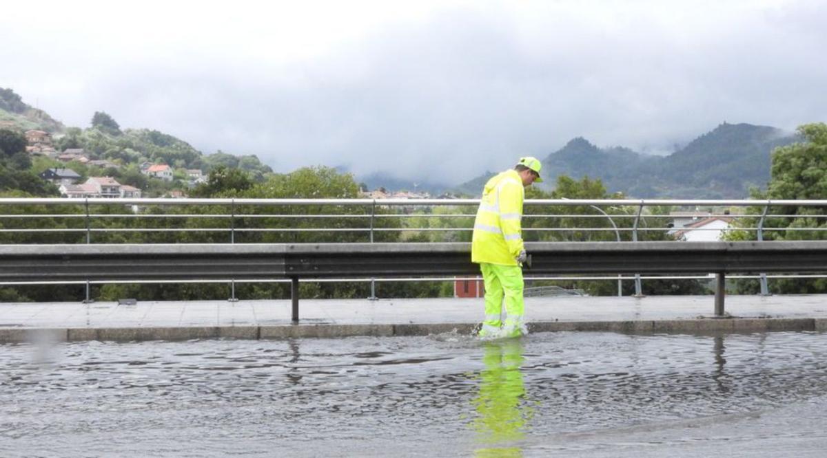 Un operario, en el Puente Novísimo, también inundado.   | // F. CASANOVA