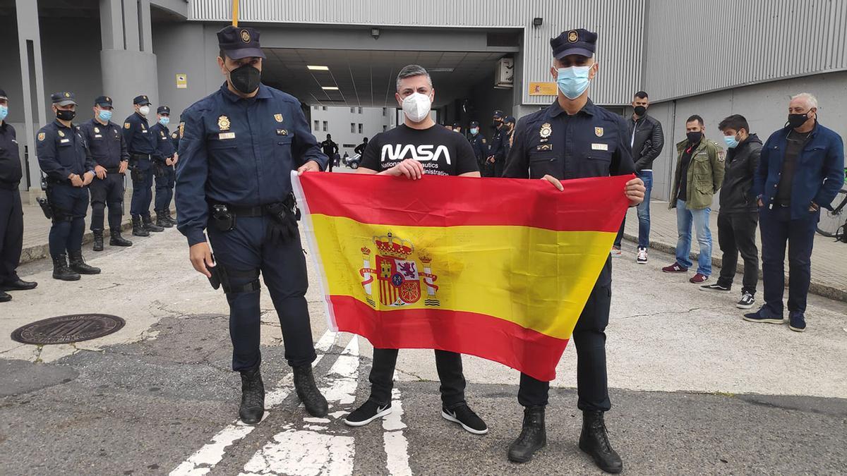 Ángel Hernández, en el centro, con la bandera que le regalaron sus compañeros en su despedida.