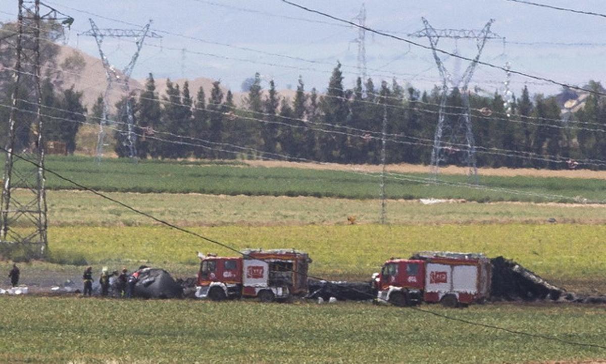 Els equips d’emergència i els bombers, al costat de l’avió sinistrat, aquest dissabte, a l’aeroport de San Pablo de Sevilla.