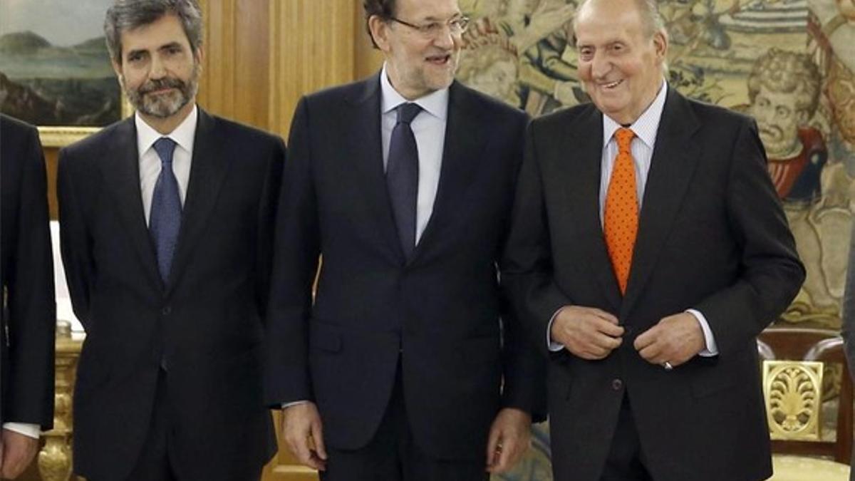 Rajoy y el Rey conversan durante el acto protocolario de toma de posesión de Carlos Lesmes, como presidente del TS
