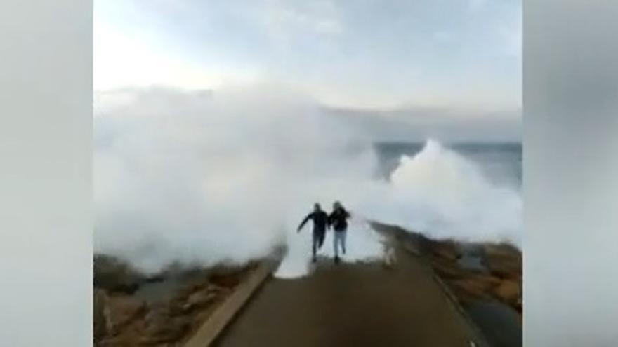 Una ola &quot;se come&quot; a dos turistas mientras se hacen un &#039;selfie&#039; al lado de la Torre de Hércules