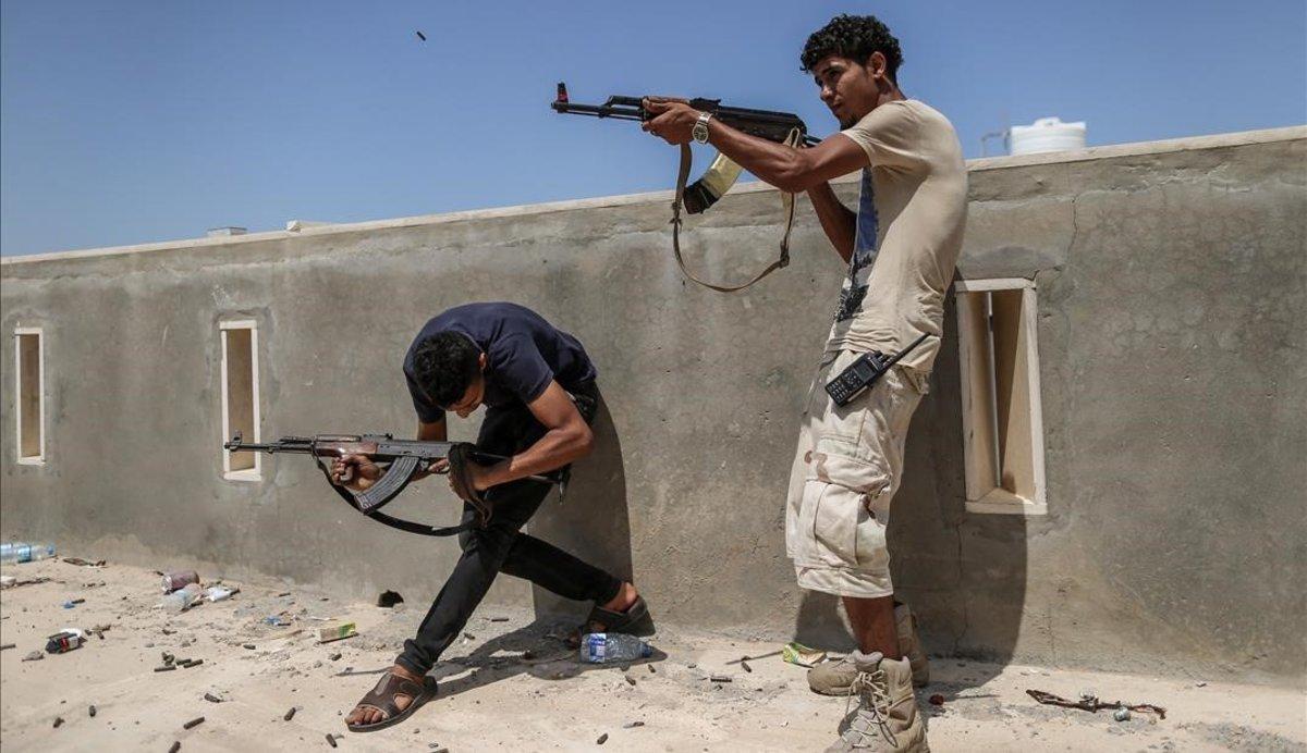 Combatientes de las tropas del Gobierno reconocido internacionalmente disparan sus armas durante un enfrentamiento con las fuerzas del autodenominado Ejército Nacional Libio, lideradas por el general Haftar.