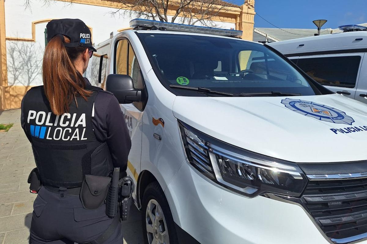 Una agente de la Policía Local de Palma junto al coche patrulla.