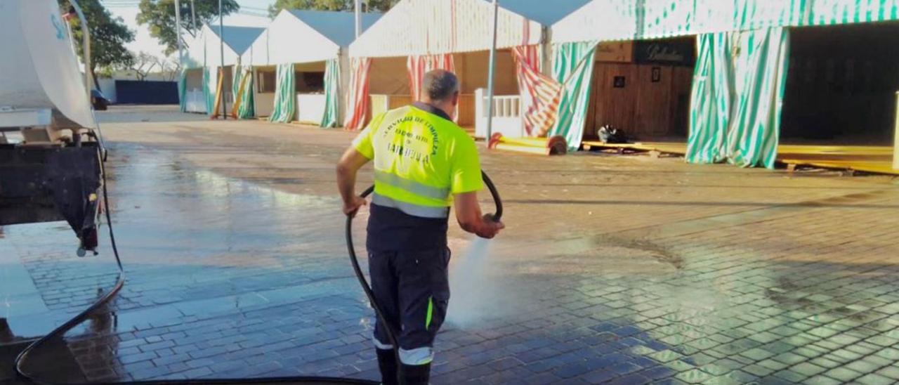 Un operario baldea el recinto ferial en la finca La Caridad la jornada previa al inicio de la Semana Grande de San Pedro Alcántara.