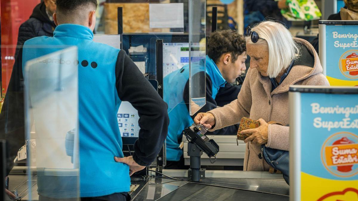 Una mujer compra en un supermercado Caprabo, marca propiedad del grupo Eroski.