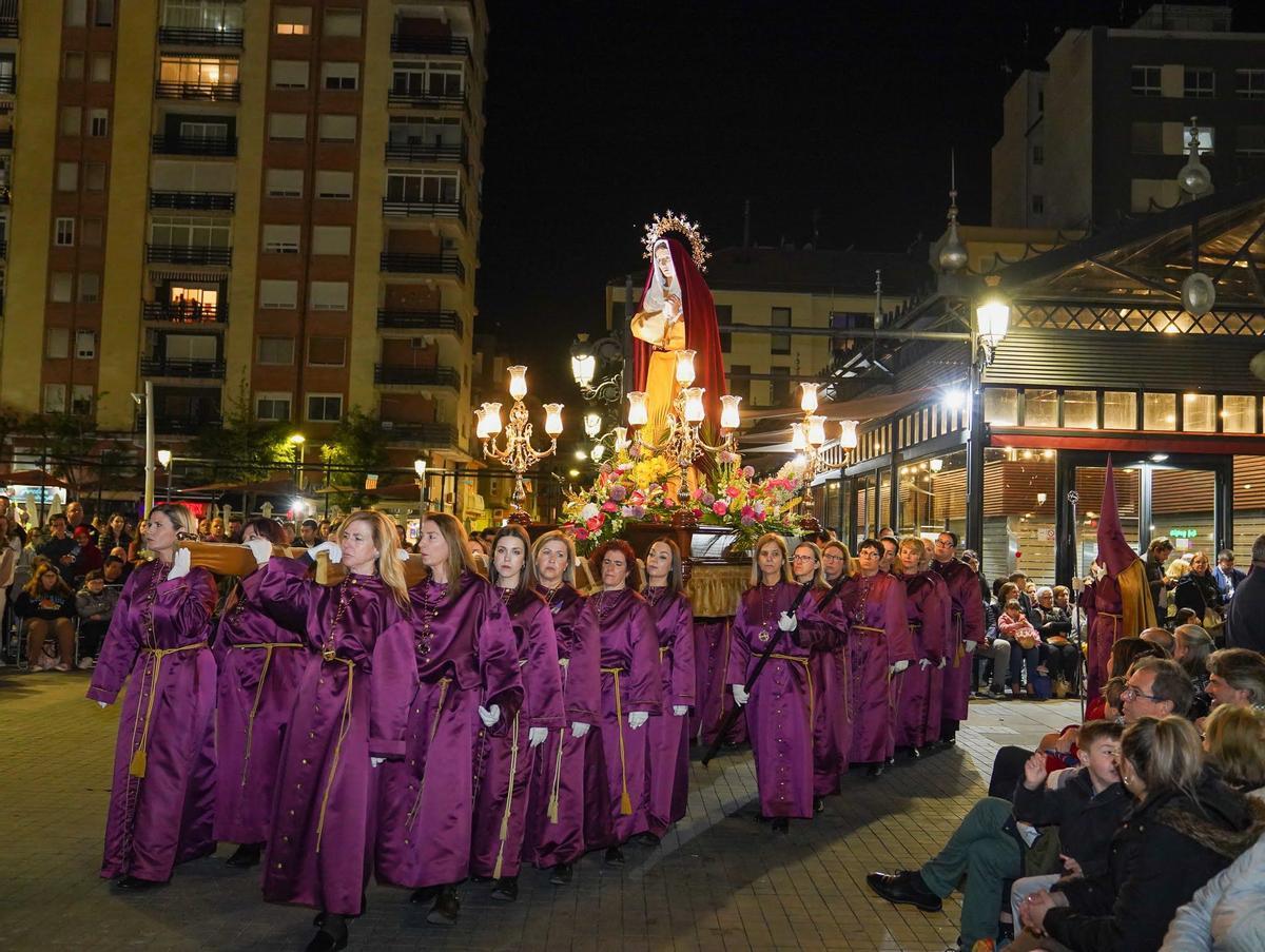 Decenas de mujeres portadoras ante la imagen en una de las calles de Gandia.