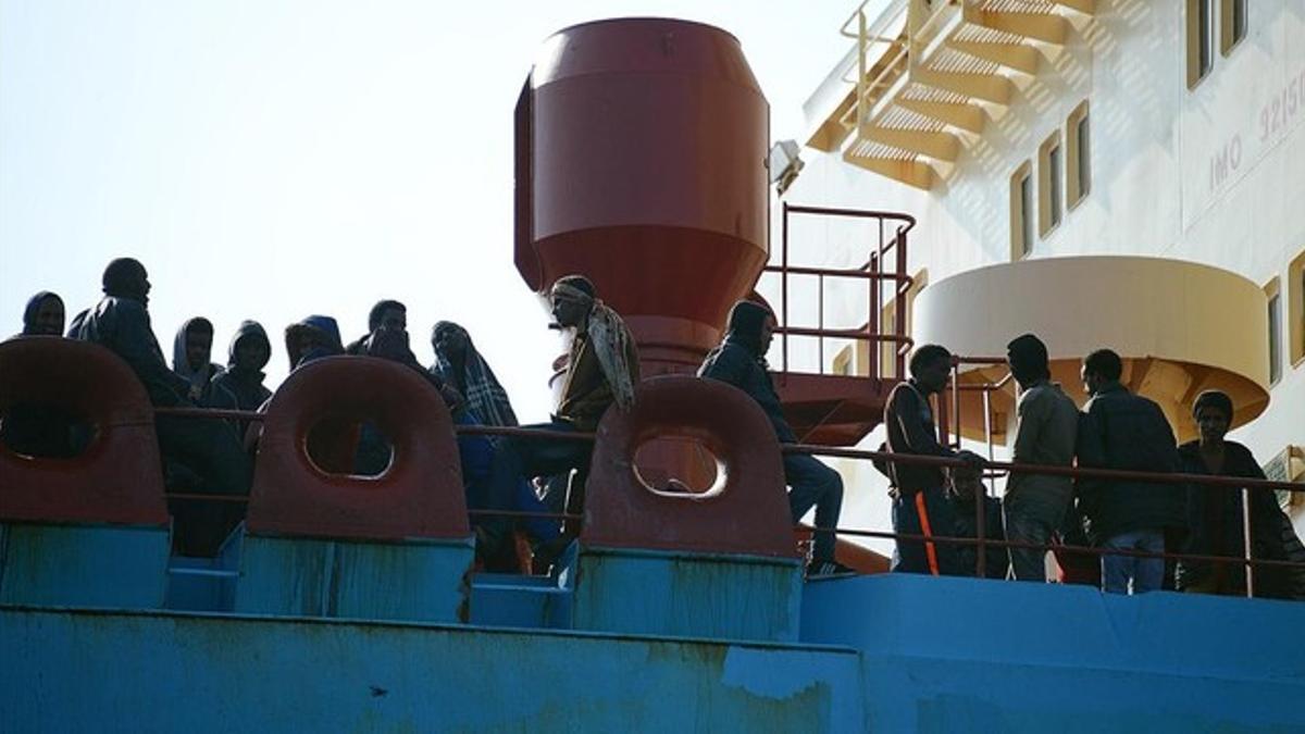 Inmigrantes 'sin papeles' en la cubierta de un buque, en el puerto siciliano de Messina.