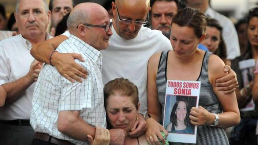 Mari Carmen Iglesias, con la foto de su hermana, arropa a sus padres en una concentración.  // G. Santos